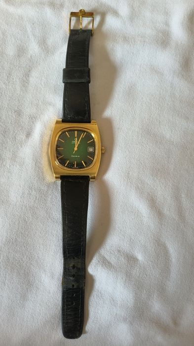 Relógio OMEGA TV DIAL com fundo verde.