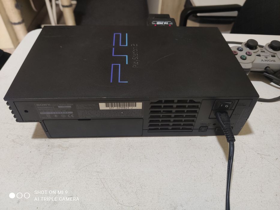 PS2 com comando e um jogo