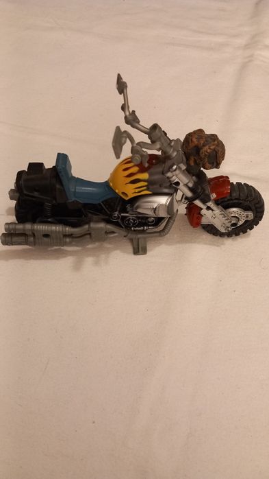 Mota de brinquedo que se assemelha a modelos como a G.I. Joe Dreadnok Cycle ou a Chap Mei Bad Guyz Cycle.