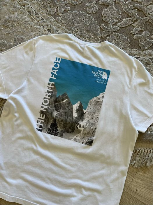 Білосніжна футболка The North Face з принтом гір на спині