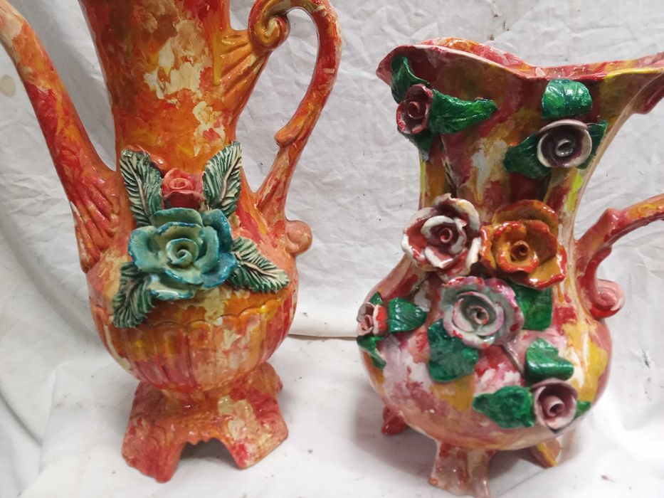 2 Jarros louça em tons rosa com flores em alto relevo.