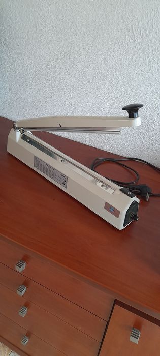 Máquina  de selar/fechar sacos de plástico até  20  cm de largura.