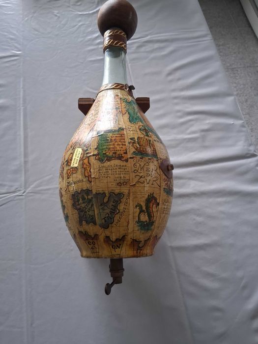decantador de vidro vintage envolvida em couro com um mapa do mundo