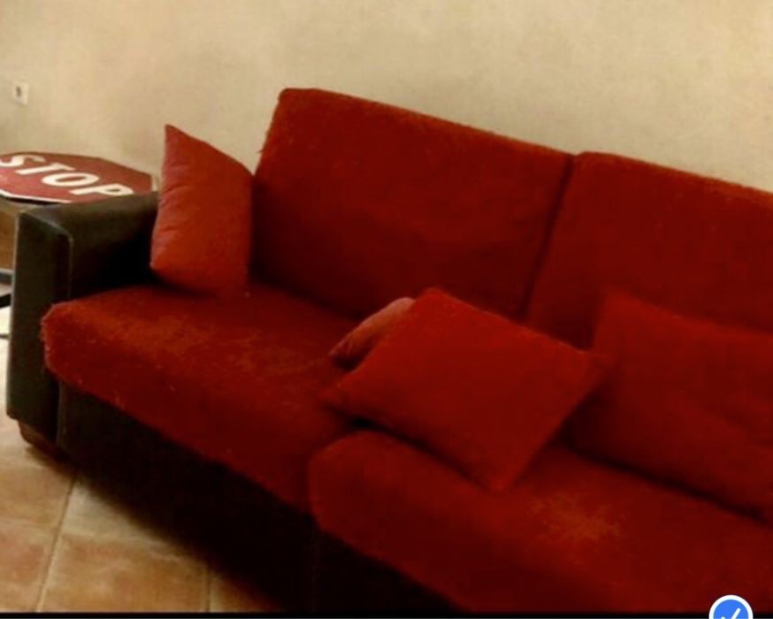 Sofá castanho em pele, com encostos e assentos em almofadas,.