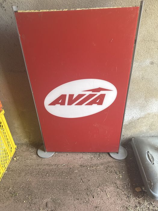 painel de publicidade vermelho apresenta o logotipo da marca de postos de abastecimento AVIA.
