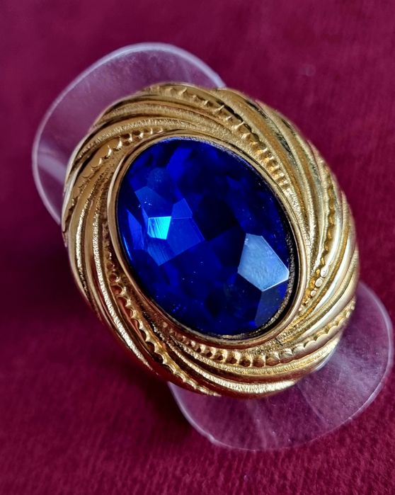 Anel dourado, em aço, com grande pedra oval azulão. T18
