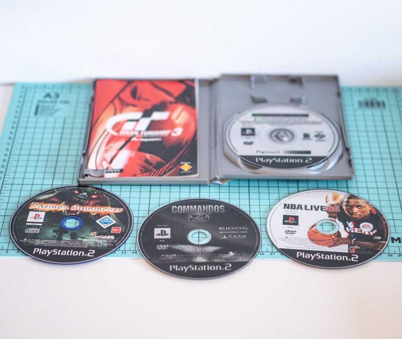 Consola PlayStation 2 Slim + 2 Comandos + 2 Memory Cards + 4 Jogos