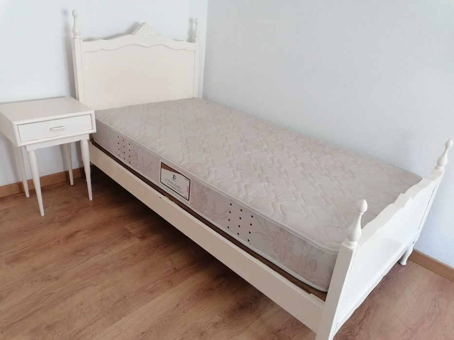 Cama de solteiro, branca, com colchão + mesa de cabeceira.