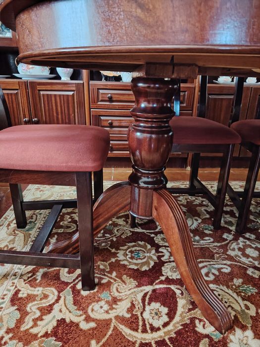 Mesa de sala de jantar com 6 cadeiras forradas a veludo rosa.