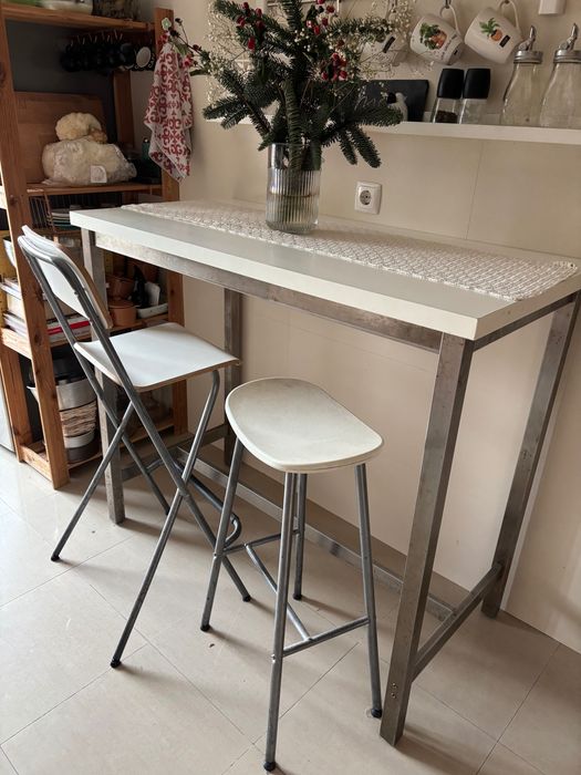 Mesa alta com duas cadeiras e um banco