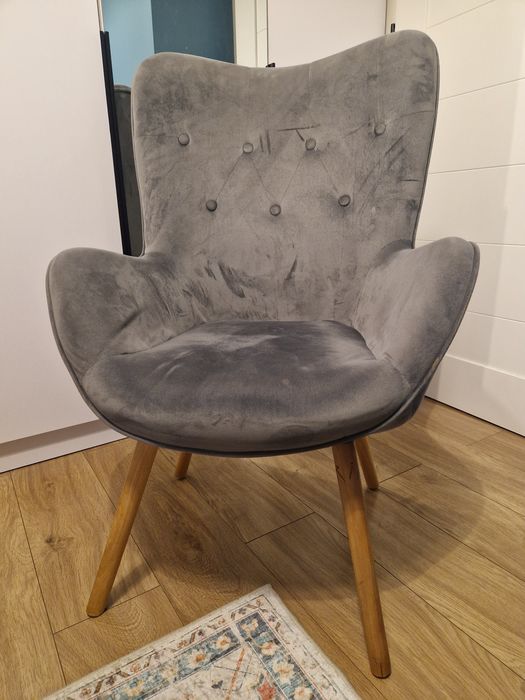 Fotel szary z nogami w koleorze naturalnego drewna