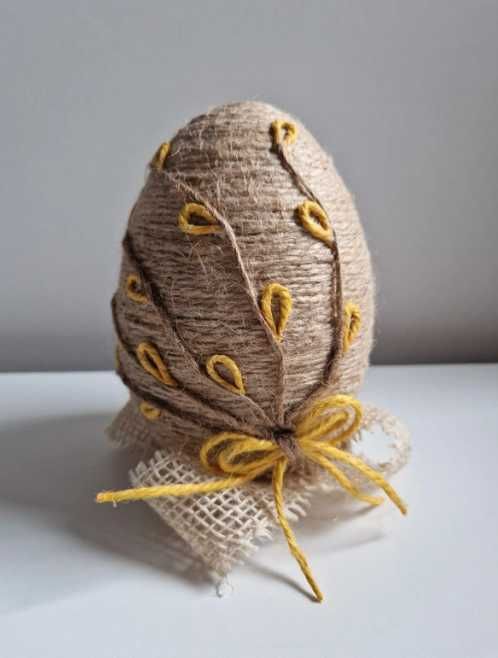 Jajko wielkanocne ręcznie robione z juty na dekoracyjnym stojaku
