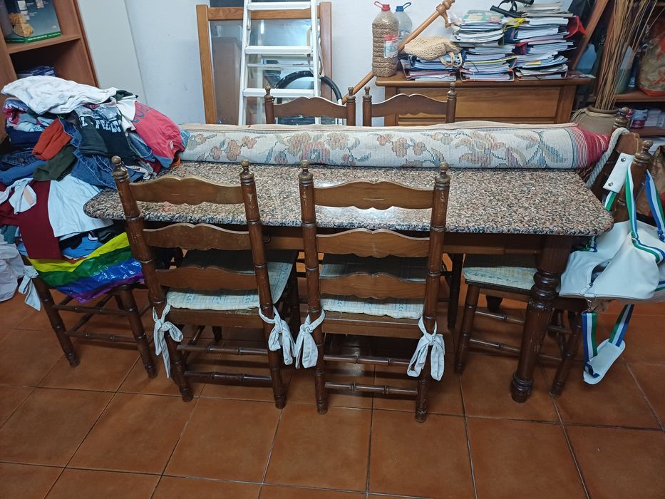 Mesa de cozinha com tampo em pedra, seis cadeiras e suas proteções