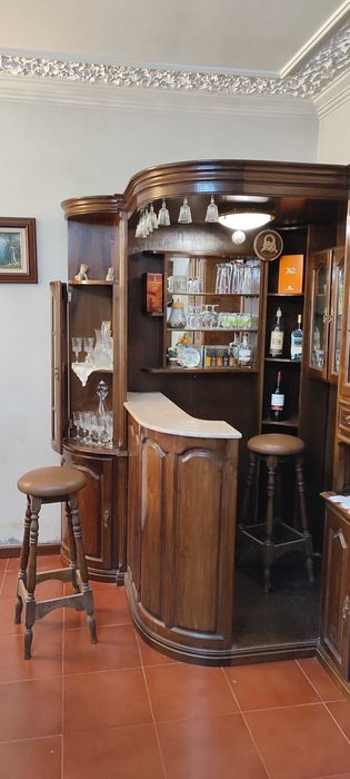 Bar de canto com vidros facetados, balcão, vitrines e 2 bancos
