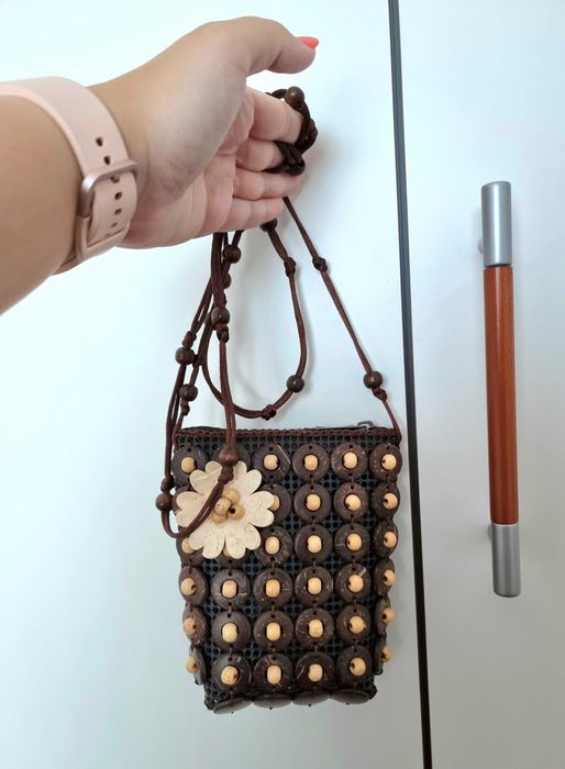 Mala pequena castanha com detalhes e uma flor