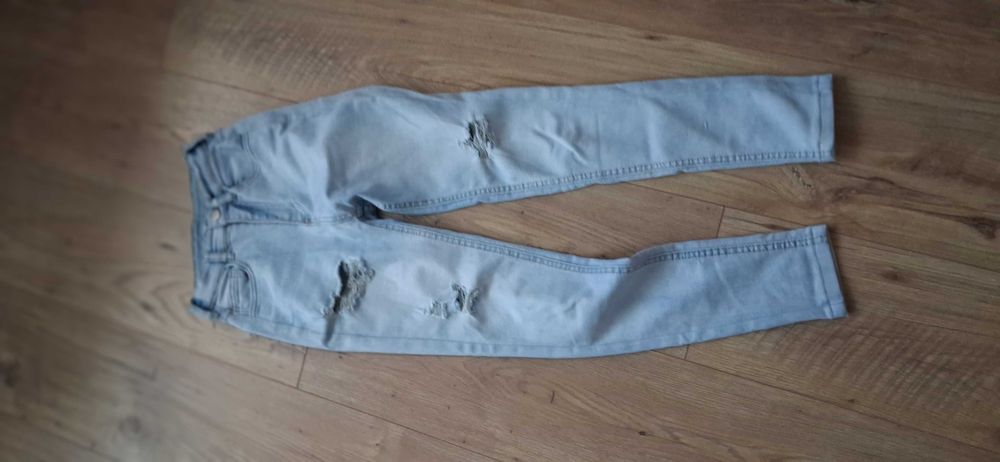 Jasnoniebieskie jeansy rurki (skinny) z wysokim stanem i modnymi dziurami/przetarciami.