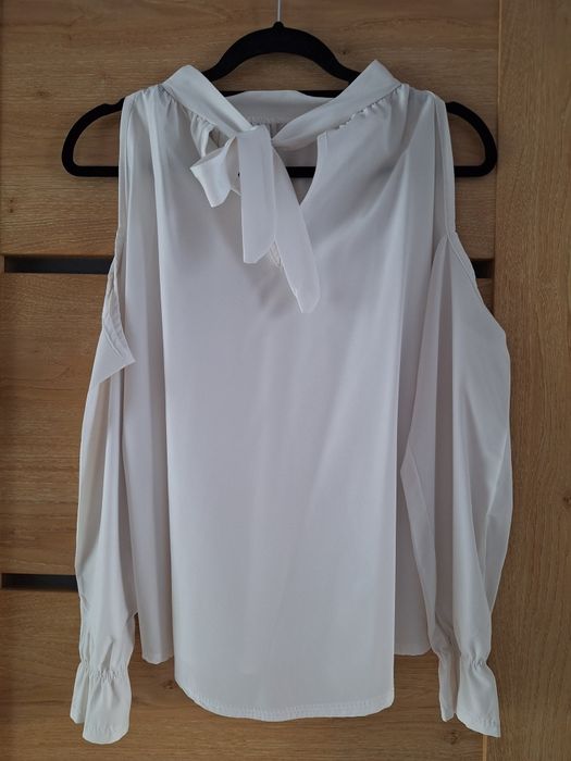 Biała bluzka z wycięciem na ramiona i ozdobnym wiązaniem na tyle