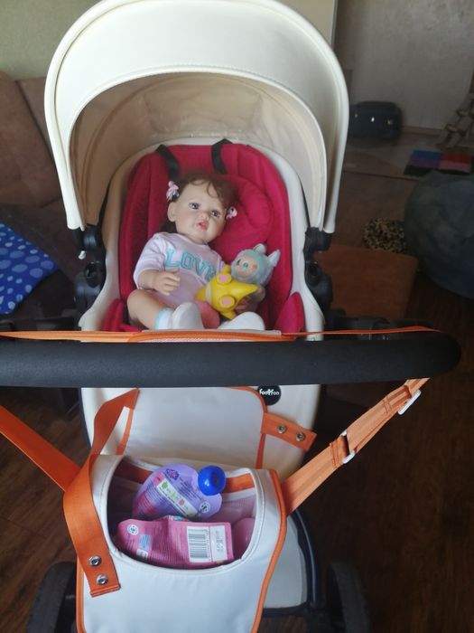 Коляска для дитини, білого кольору.