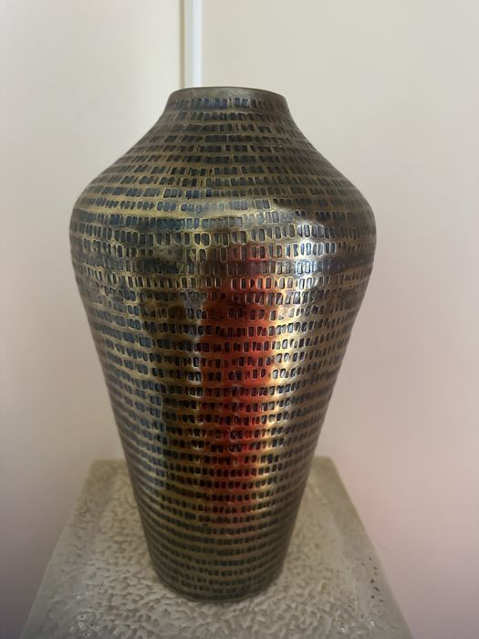 vaso em metal cor bronze com um acabamento lindo