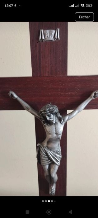 Crucifixo de mesa composto por uma cruz de madeira escura com uma base escalonada de vários níveis.A figura tridimensional do corpo de Cristo (corpus)