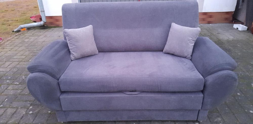 Szara sofa kanapa z funkcją spania i pojemnikiem na pościel
