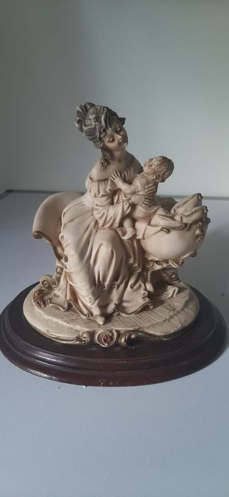 Escultura de mãe e filho em base de madeira