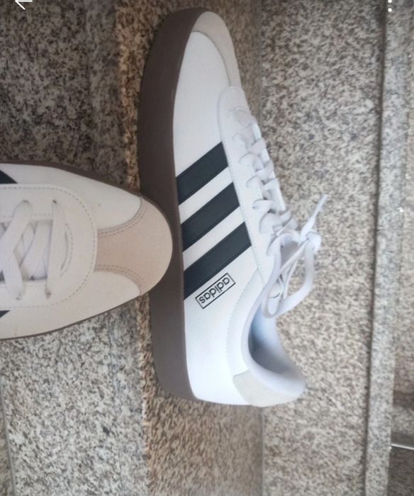 Sapatilhas adidas VL Court 3.0 brancas com detalhes pretos e sola de borracha castanha.