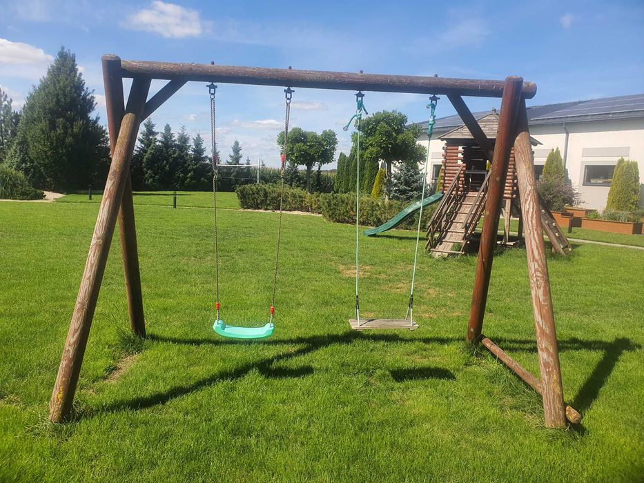 Drewniany domek ogrodowy ze zjeżdżalnią dla dzieci