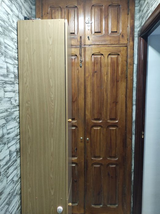 Дерев'яні двері, килимові доріжки, тумби в прихожу