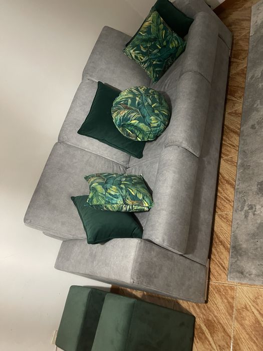 Sofa novo com almofadas decorativas e dois pufs