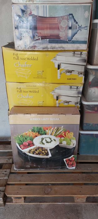quatro rechauds em aço inoxidável, dois dispensadores de bebidas em vidro e uma grande bandeja giratória.