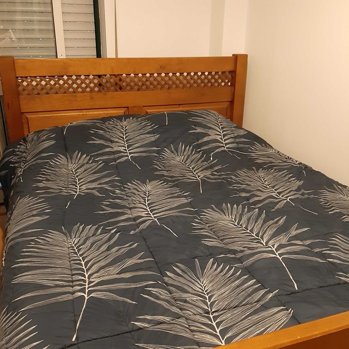 Cama com extrado e duas mesas de cabeceira.