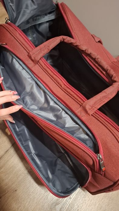 Дорожня вмістка сумка на колесах червоного кольору. Нова.