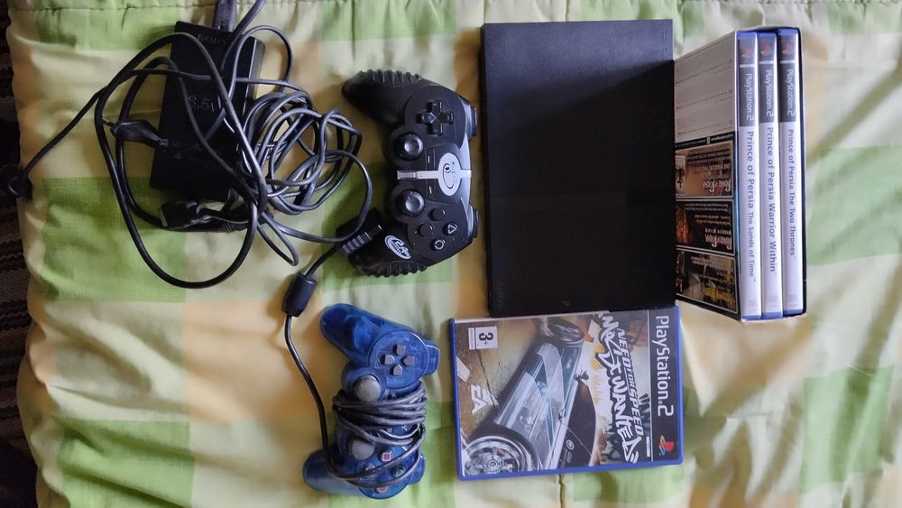 PlayStation 2 com dois jogos clássicos e dois comandos