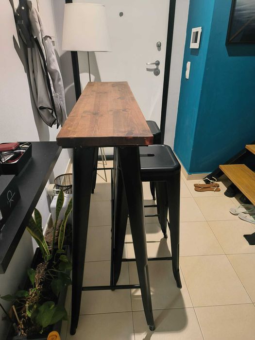Mesa alta com tampo de de madeira natural e duas cadeiras