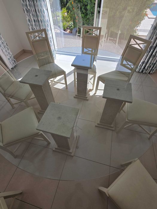 Mesa de jantar de vidro com pilares de mármore