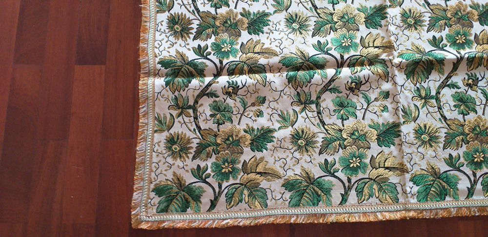 Vendo colcha com padrão de flores em verde e dourado