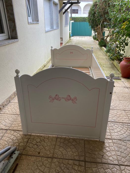 Cama branca com detalhes cor de rosa