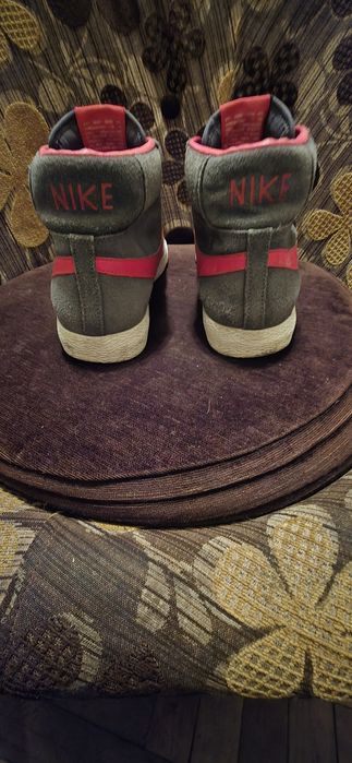 To są szare zamszowe buty Nike Blazer Mid z czerwonymi akcentami.