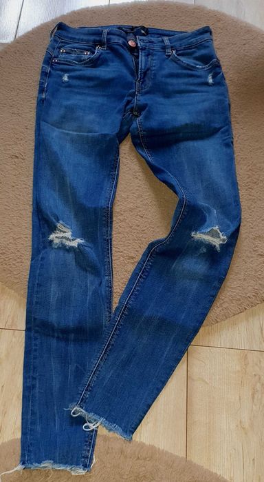 Dżinsy "rurki" damskie z dziurami od Bershka