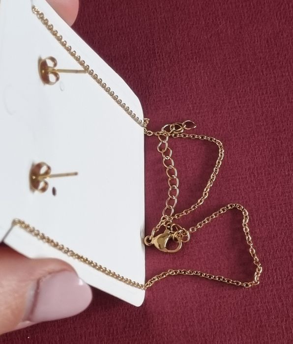 Conjunto dourado (colar e brincos), em aço, com trevo estriado.