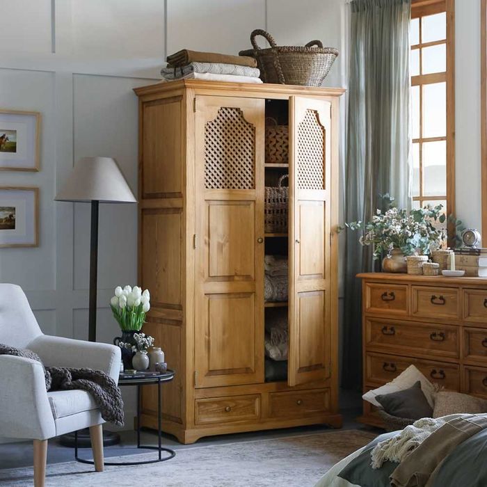Drewniana szafa z ażurowymi drzwiami w stylu wiejskim, rustykalnym