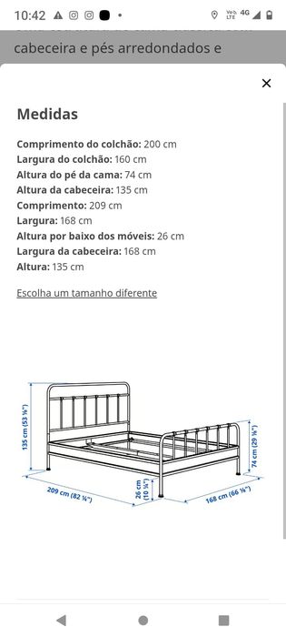 Cama de ferro e colchão Queen . O colchão possui uma capa em tecido.