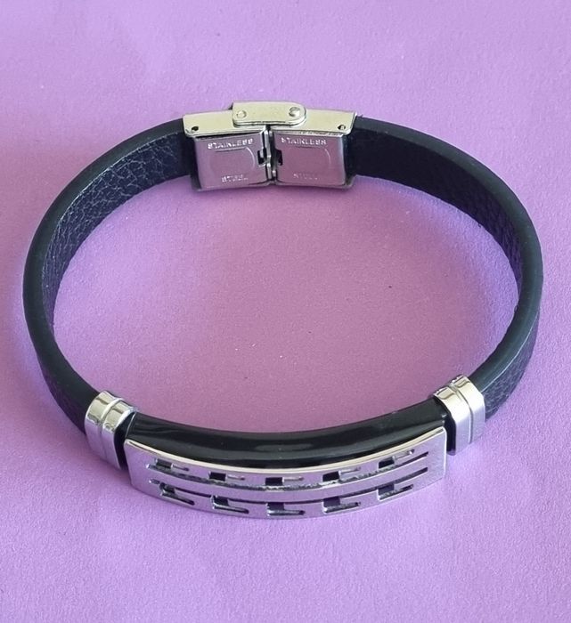 Pulseira de cabedal preto com peças prateadas em aço inoxidável.