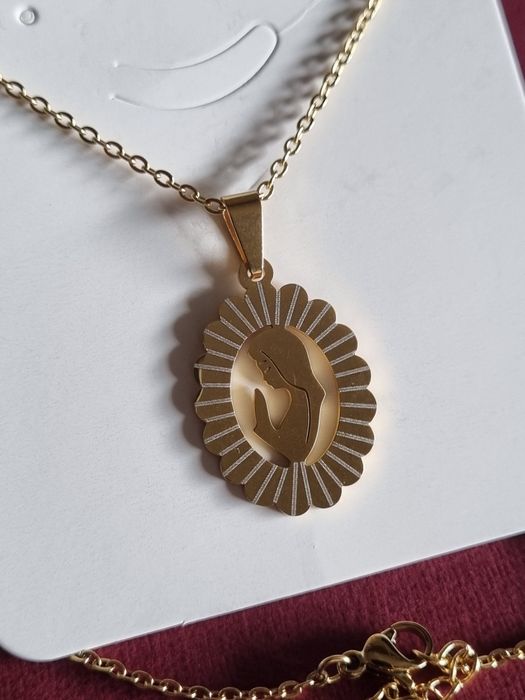 Colar prateado/dourado, em aço, com pingente da Nossa Senhora. Tem extensor