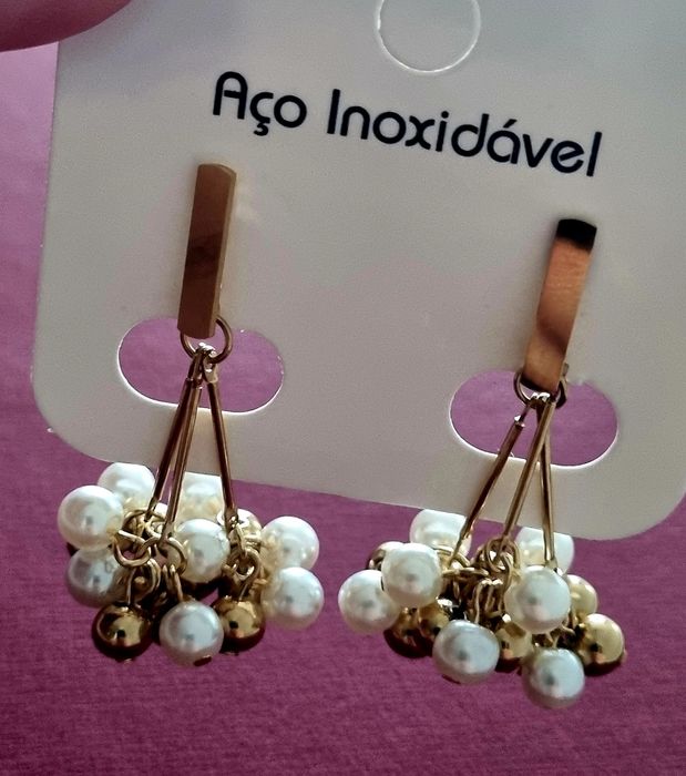 Brincos dourados, em aço, com muitas pérolas e bolinhas douradas ao penduro. De pico.