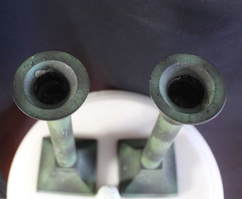 Par de castiçais antigos de latão com pátina esverdeada.