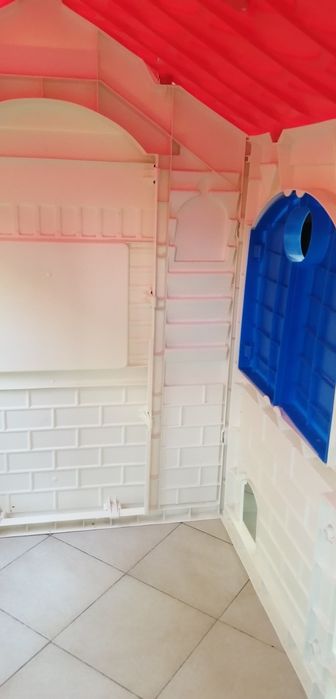 Casa de jardim de criança de plástico com telhado vermelho em bom estado