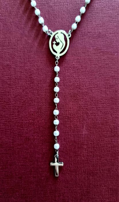 Colar prateado, em aço, em forma de terço com pequenas pérolas.