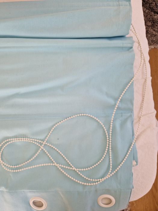 Cortinado azul com ilhos na extremidade